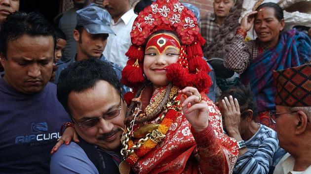 File photo taken on March 29, 2006 shows a priest carrying Nepal's Living Goddess 'Kumari Devi' (centre) during the Ghode Jatra festival in Kathmandu. A three-year-old girl has been named the new Kumari of Nepal's capital Kathmandu after her predecessor retired when she reached puberty, continuing an ancient tradition that sees young girls worshipped as “living goddesses”.(AFP)