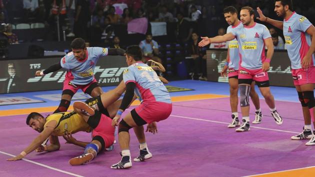 Telugu Titans player Rahul Chaudhari (left) successfully touches the line as Jaipur Pink Panthers defenders try to pin him down during their Pro Kabaddi League (PKL) match in New Delhi (AP) Telugu Titans player Rahul Chaudhari (left) successfully touches the line as Jaipur Pink Panthers defenders try to pin him down during their Pro Kabaddi League (PKL) match in New Delhi (AP)