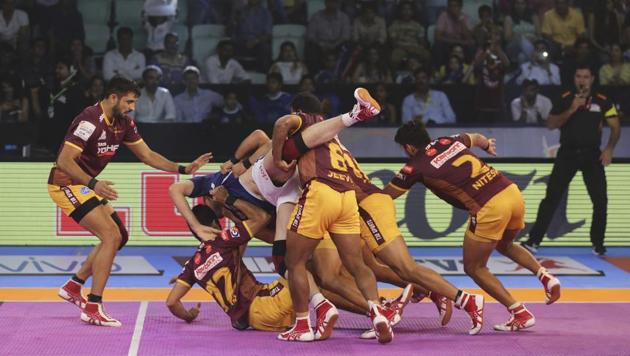 UP Yoddha players pin down Dabang Delhi player Abolfazl Maghsodlou, in blue jersey, during their Pro Kabaddi League match in New Delhi on Wednesday.(AP)