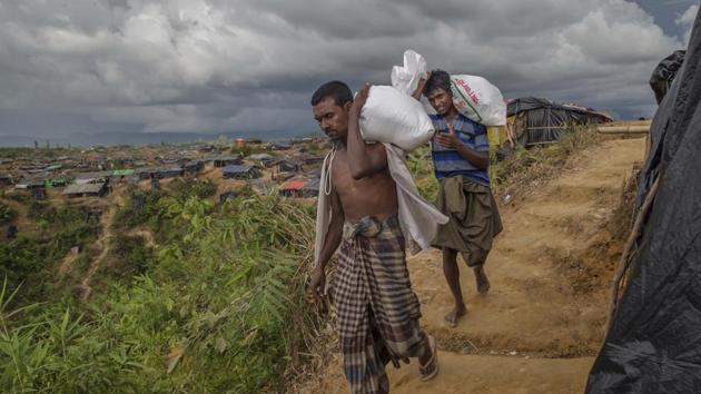 Rohingya Muslims who crossed over from Myanmar into Bangladesh, walk back to their shelters after collecting aid in Taiy Khali refugee camp, Bangladesh, Wednesday, Sept. 27, 2017.(AP Photo)