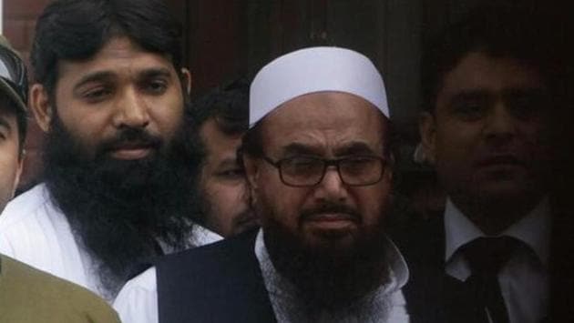 Hafiz Saeed (right), chief of the Jamaat-ud-Dawa (JuD), leaves after appearing in a court to challenge his house arrest in Lahore, Pakistan, on May 13, 2017.(Reuters)
