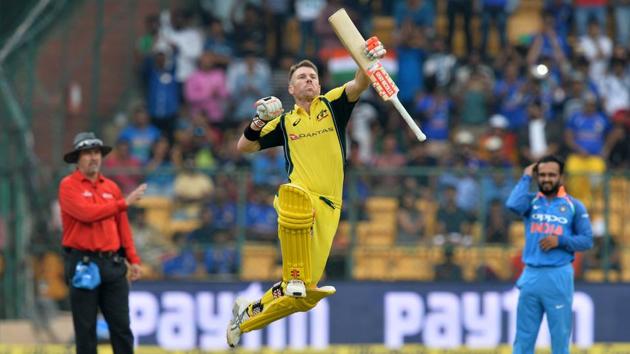 Australian cricketer David Warner jumps to celebrate his century during the fourth ODI against India at the M. Chinnaswamy Stadium in Bangalore on Thursday.(AFP)
