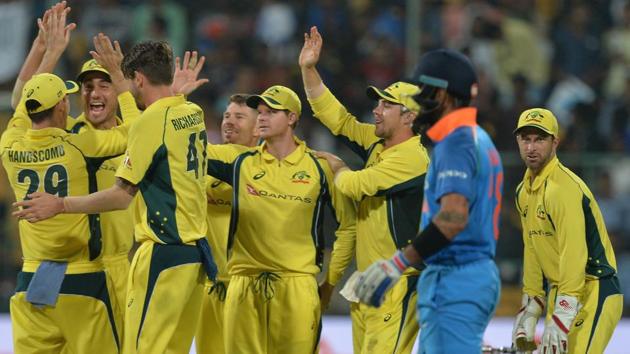 Australian cricket team players celebrate after the dismissal of an Indian batsman during the fourth ODI in Bangalore.(AFP)