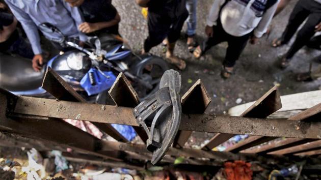 A slipper of an injured commuter is seen stuck on the railing of a pedestrian bridge where a stampede took place at the Elphinstone station in Mumbai on Friday.(PTI Photo)