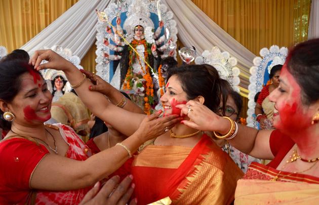 The ritual is part of the Durga Puja celebrations when women put vermilion on the forehead and feet of the goddess before wishing a blessed marital life for one another. (ravi kumar/HT)