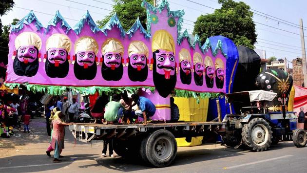 People carry an effigy of the demon King Ravana for installation, on the eve of Dussehra festival in Amritsar on Friday.(PTI)