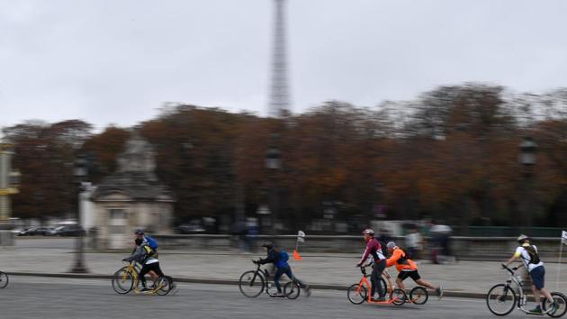 People ride on bicycle-scooters along the Place de la Concorde back dropped by the Eiffel Tower during a ‘car free’ day in Paris on October 1, 2017.(AFP Photo)