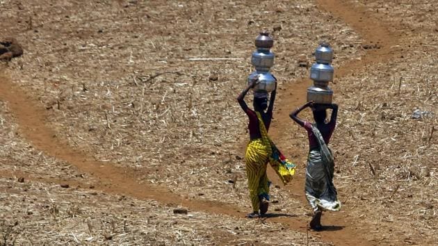 Women walk home after collecting drinking water from a well at Mengal Pada in Thane district in Maharashtra.(AP File Photo)