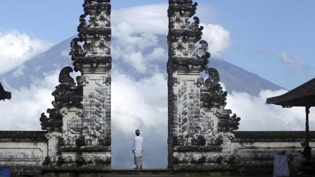 A man watches the Mount Agung volcano from a temple in Karangasem, Bali, Indonesia, on Tuesday, Sept. 26, 2017. A week after authorities announced a high alert, tremors that indicate an eruption is coming show no sign of abating, swelling the exodus from the region to at least 140,000 people. (Firdia Lisnawati / AP) A man watches the Mount Agung volcano from a temple in Karangasem, Bali, Indonesia, on Tuesday, Sept. 26, 2017. A week after authorities announced a high alert, tremors that indicate an eruption is coming show no sign of abating, swelling the exodus from the region to at least 140,000 people. (Firdia Lisnawati / AP)