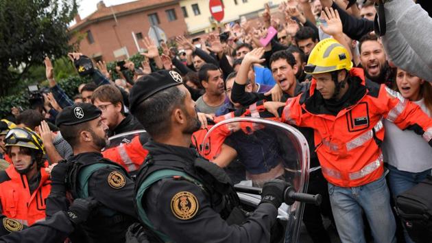 Firemen try to hold a group of people in front of Spanish Guardia Civil officers outside a polling station in San Julia de Ramis. (Lluis Gene/AFP Photo) Firemen try to hold a group of people in front of Spanish Guardia Civil officers outside a polling station in San Julia de Ramis. (Lluis Gene/AFP Photo)