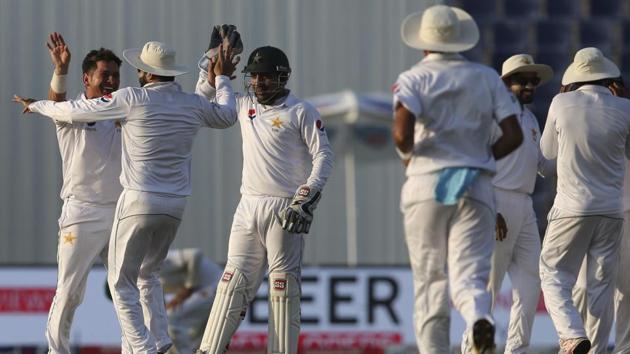 Pakistan's Yasir Shah celebrates with his teammates after dismissing Sri Lanka's Dinesh Chandimal during the fourth day of the first Test in Abu Dhabi on Sunday.(AP)