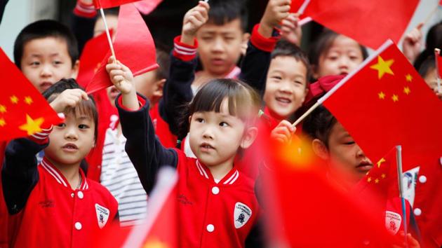 Children wave national flags as they sing revolutionary songs to celebrate the National Day at a kindergarten in Tonglu, China. (AFP) Children wave national flags as they sing revolutionary songs to celebrate the National Day at a kindergarten in Tonglu, China. (AFP)