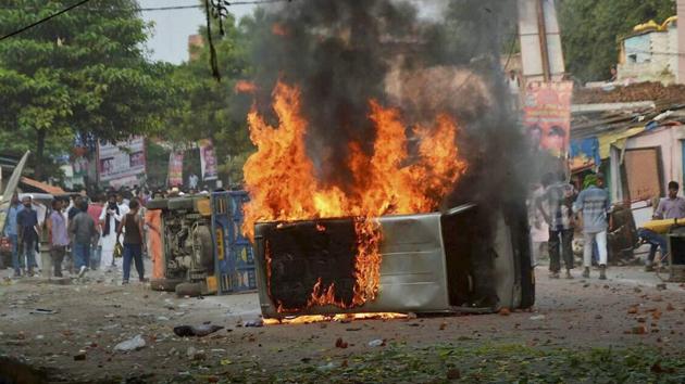 Vehicles set on fire after a clash between two communities during a Muharram procession at Parampurva in Kanpur on Sunday.(PTI Photo)