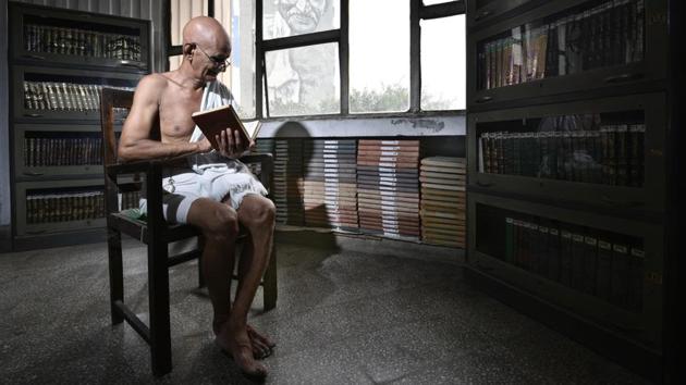 Mahesh Chaturvedi sits in a public library in central Delhi that faces a life-size mural of his idol and inspiration Mahatma Gandhi. The 68-year-old Chaturvedi calls himself a modern-day Gandhi -- complete with round glasses, a crisp white dhoti and a message to wipe out poverty.(Arun Sharma / HT Photo)