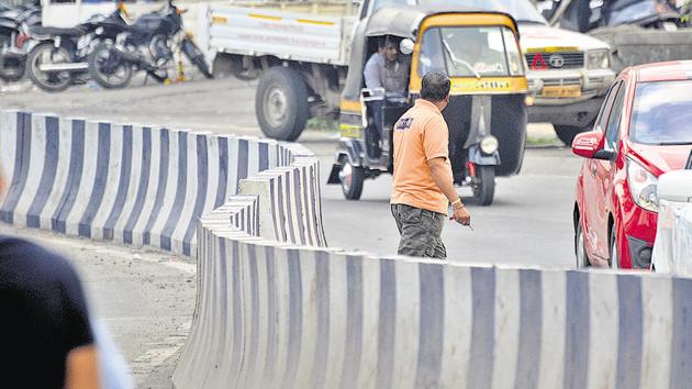 Pedestrians cross the accident-prone spot located at Baner road in Pune.(Ravindra Joshi/HT PHOTO)