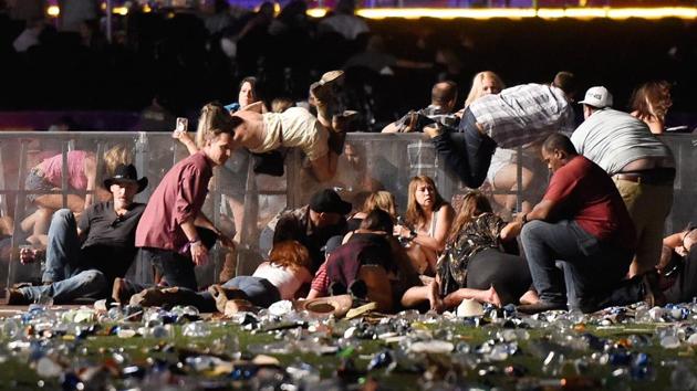 People scramble for shelter at the Route 91 Harvest country music festival after apparent gun fire was heard on October 1, 2017 in Las Vegas, Nevada. (AFP) People scramble for shelter at the Route 91 Harvest country music festival after apparent gun fire was heard on October 1, 2017 in Las Vegas, Nevada. (AFP)