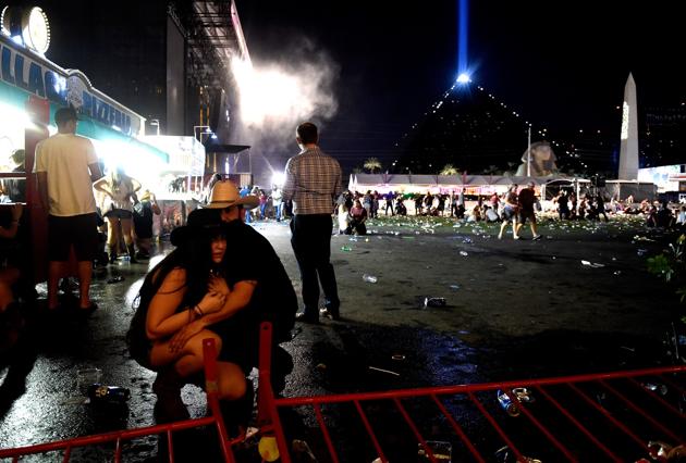 People take cover at the Route 91 Harvest country music festival after gun fire was heard on October 1 in Las Vegas, Nevada.(AFP Photo)