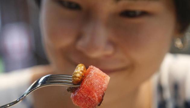 Amornrat Simapsaisan, a local shop manager, watches before she eats a watermelon salad with bamboo worms.(AP)