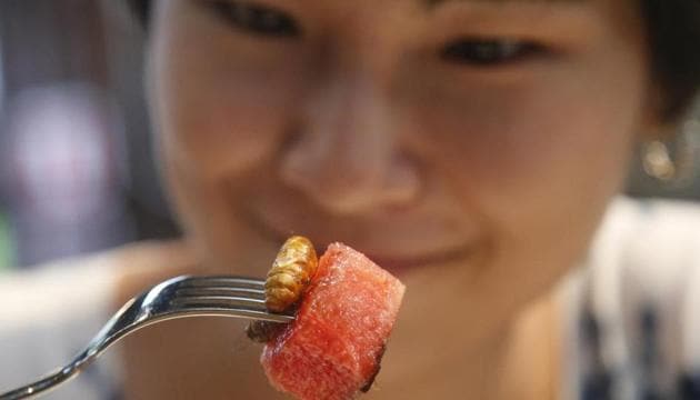 Amornrat Simapsaisan, a local shop manager, watches before she eats a watermelon salad with bamboo worms. (AP) Amornrat Simapsaisan, a local shop manager, watches before she eats a watermelon salad with bamboo worms. (AP)
