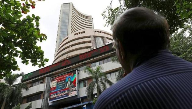 A man looks at a screen across a road displaying the Sensex on the facade of the Bombay Stock Exchange (BSE) building in Mumbai, India. (Reuters File Photo) A man looks at a screen across a road displaying the Sensex on the facade of the Bombay Stock Exchange (BSE) building in Mumbai, India. (Reuters File Photo)