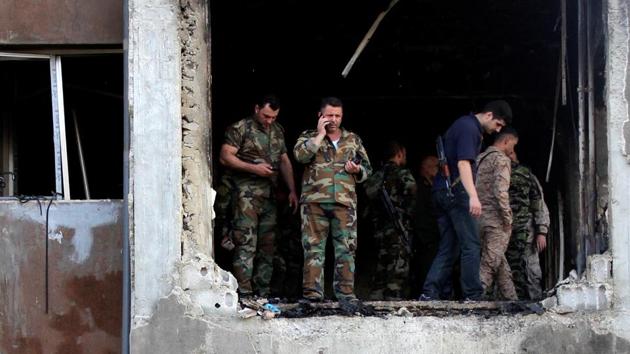 Syrian army soldiers stand in a damaged building at a site where suicide bombers attacked a police station in Damascus, Syria October 2, 2017. (REUTERS) Syrian army soldiers stand in a damaged building at a site where suicide bombers attacked a police station in Damascus, Syria October 2, 2017. (REUTERS)
