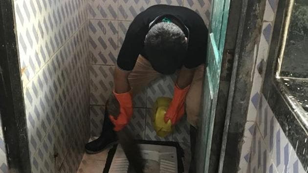 Deputy municipal commissioner Manish Joshi cleans a toilet in Thane. Deputy municipal commissioner Manish Joshi cleans a toilet in Thane.
