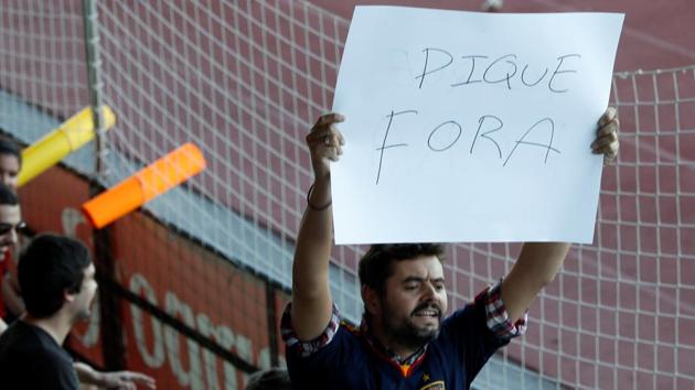 A man displays a banner that reads "Pique Out", referring to Spain and FC Barcelona player Gerard Pique, before a training session of the Spain national football team in Las Rozas, near Madrid, on Monday. (REUTERS) A man displays a banner that reads "Pique Out", referring to Spain and FC Barcelona player Gerard Pique, before a training session of the Spain national football team in Las Rozas, near Madrid, on Monday. (REUTERS)