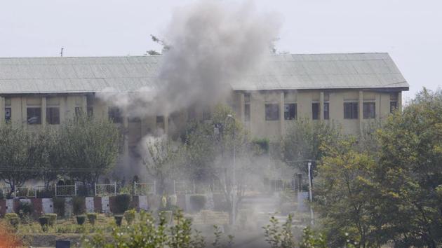 Smoke billows out of the building where militants were believed to be hiding during an encounter with the security forces following their attack at a BSF camp, near the international airport in Srinagar on Tuesday.(Waseem Andrabi/HT Photo)