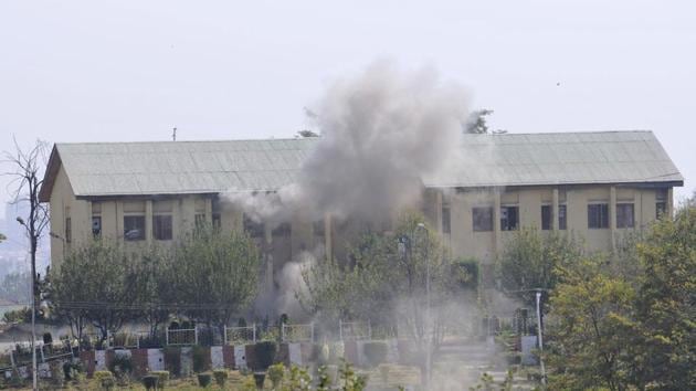 Smoke billows out of the building where militants were believed to be hiding during an encounter with the security forces following their attack at a BSF camp, near the international airport in Srinagar on Tuesday.(Waseem Andrabi/HT)