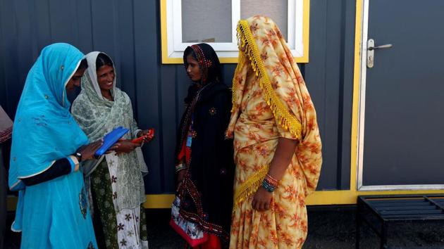 Outside of the gruelling training sessions in Islamkot, the women share a light moment before climbing into heavy 60-tonne trucks. (Akhtar Soomro / REUTERS)