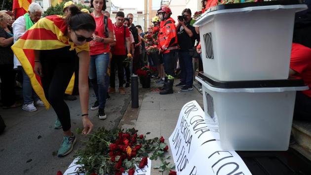 People place flowers in front of ballot boxes during a protest against police actions during the banned independence referendum in front of city hall in Pineda de Mar, north of Barcelona. (Albert Gea / REUTERS) People place flowers in front of ballot boxes during a protest against police actions during the banned independence referendum in front of city hall in Pineda de Mar, north of Barcelona. (Albert Gea / REUTERS)