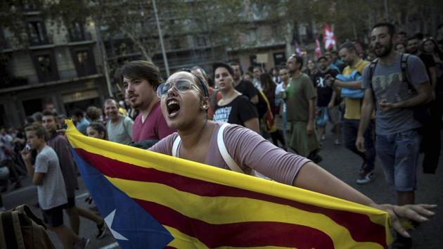 In Barcelona, a woman carries an independence Catalan flag as demonstrators marched downtown. (PTI / AP) In Barcelona, a woman carries an independence Catalan flag as demonstrators marched downtown. (PTI / AP)