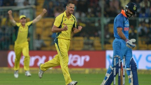 Australia cricket team bowler Nathan Coulter-Nile celebrates after bowling out Indian cricket team captain Virat Kohli (R) during the fourth ODI at M Chinnaswamy Stadium in Bangalore on September 28.(AFP)