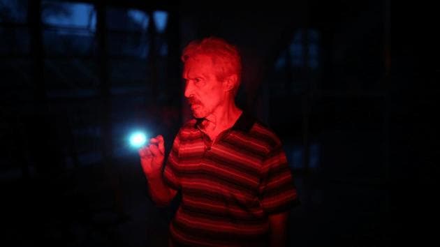 A man uses a flashlight at the Moradas Las Teresas Elderly House, where about two hundred elderly people are living without electricity following damages caused by Hurricane Maria. (Carlos Barria / REUTERS)