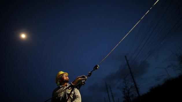 A worker repairs an electrical line following damages caused by the hurricane in San Juan. Shortly after Trump left Puerto Rico, Governor Ricardo Rosello said the death toll had risen from 16 to 34. (/Carlos Barria / REUTERS)