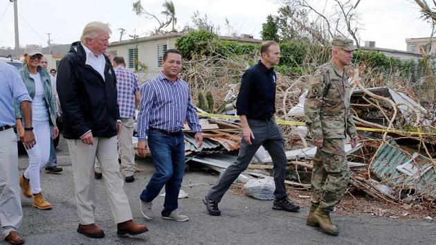 U.S. President Donald Trump walks past wreckage caused by Hurricane Maria as he participates in a walking tour with First Lady Melania Trump (L) in damaged areas in Guaynabo, Puerto Rico, U.S. Nearly two weeks after the storm, 95 percent of electricity customers remain without power, including some hospitals. US President expressed satisfaction on Tuesday with the federal response to Hurricane Maria’s devastation of Puerto Rico, despite criticism that the government was slow to address the crisis. (Jonathan Ernst / REUTERS )