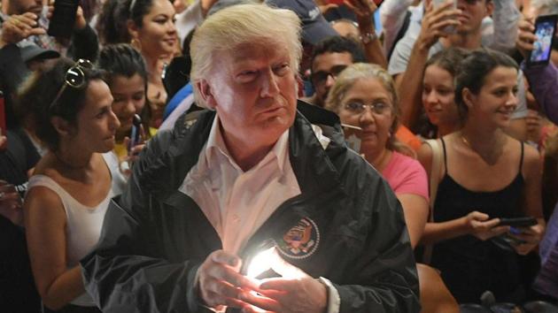 US President Donald Trump takes part in a food and supply distribution at the Cavalry Chapel in Guaynabo, Puerto Rico on October 3, 2017. Nearly two weeks after Hurricane Maria thrashed through the US territory, much of the islands remains short of food and without access to power or drinking water.(AFP)