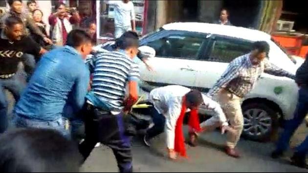 A BJP worker (wearing saffron scarf) being assaulted by supporters of Benoy Tamang in Darjeeling on Thursday.(Bikram Sashanker/ HT Photo) A BJP worker (wearing saffron scarf) being assaulted by supporters of Benoy Tamang in Darjeeling on Thursday.(Bikram Sashanker/ HT Photo)