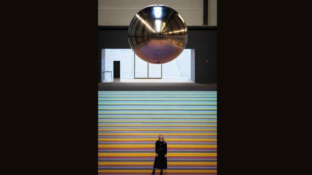 An employee poses below a pendulum, part of 'One Two Three Swing!' at Tate Modern in London, England. This is not the first interactive installation in Turbine Hall. Carsten Höller invited people to hurtle down his helter-skelters while Olafur Eliasson encouraged visitors to lie down and enjoy fake mist and sunshine. (Jack Taylor / Getty Images)