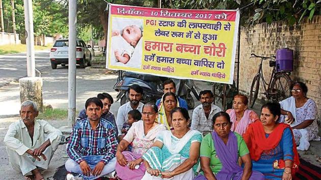 Family of the missing newborn sitting on a dharna outside the Post Graduate Institute of Medical Sciences in Rohtak on Wednesday.(Manoj Dhaka/HT)