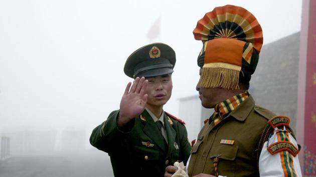 File photo taken on July 10, 2008 shows a Chinese soldier (left) gesturing to an Indian soldier at Nathu La border crossing in India's northeastern Sikkim state.(AFP)