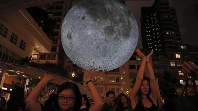 Visitors pose for photographs in front of an installation ‘Museum of the Moon’, a giant seven metre wide glowing sculpture of the moon, created by British artist Luke Jerram in Hong Kong to celebrate the Mid-Autumn Festival. Held on the 15th day of the 8th month of the lunar calendar on a full moon night, the harvest festival is also associated with traditions of moon worship and gazing. (Kin Cheung / AP)