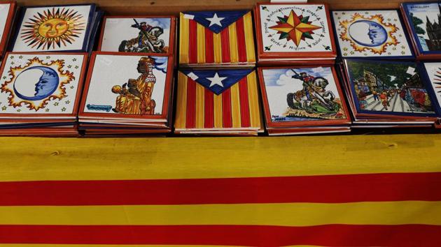 Tiles with the Estelada (Catalan separatist flag) on display on a table covered with a Catalan flag at an arts and craft market four days after the banned independence referendum, in Barcelona.(Reuters Photo)