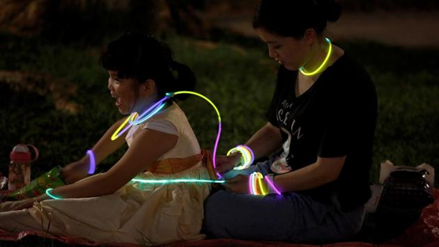 Residents play with glow sticks as they celebrate Mid-Autumn or Lantern Festival at a park in Hong Kong. (Bobby Yip / REUTERS)