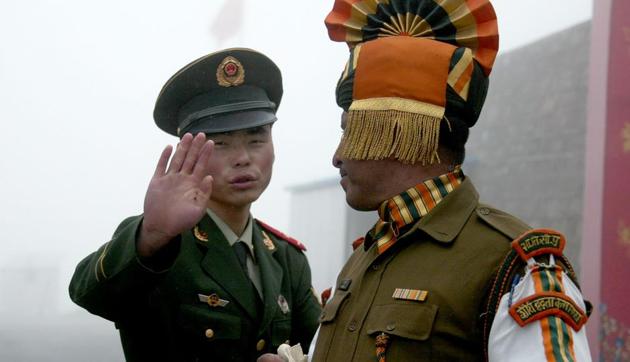 Chinese soldier gesturing next to an Indian soldier at the Nathu La border crossing between India and China in Sikkim. (AFP File Photo) Chinese soldier gesturing next to an Indian soldier at the Nathu La border crossing between India and China in Sikkim. (AFP File Photo)