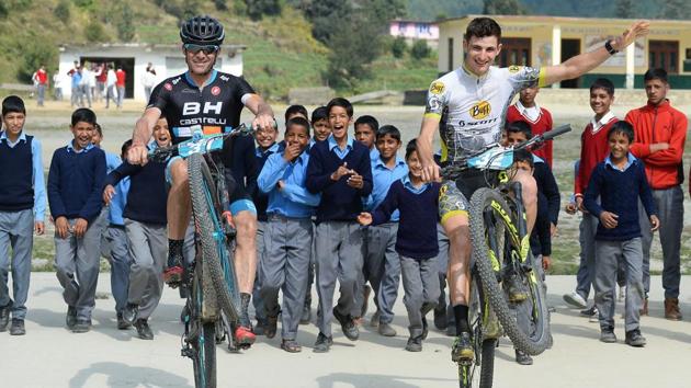 Riders Adria Noguera (R) and Antonio Ortiz (L) of Spain are seen entertaining schoolchildren from Bagshed. The initiative ‘Mission Smile,’ in its fourth year, runs along with the MTB Himalaya race and aims to educate children and their parents to eradicate open defecation and improve hygiene. (AFP / SAJJAD HUSSAIN) Riders Adria Noguera (R) and Antonio Ortiz (L) of Spain are seen entertaining schoolchildren from Bagshed. The initiative ‘Mission Smile,’ in its fourth year, runs along with the MTB Himalaya race and aims to educate children and their parents to eradicate open defecation and improve hygiene. (AFP / SAJJAD HUSSAIN)