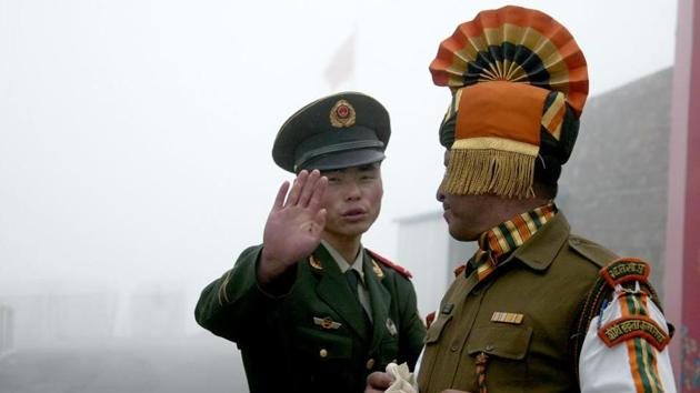 This file photo taken on July 10, 2008, shows a Chinese soldier (L) gesturing next to an Indian soldier at the Nathu La border crossing between India and China in India's Sikkim state.