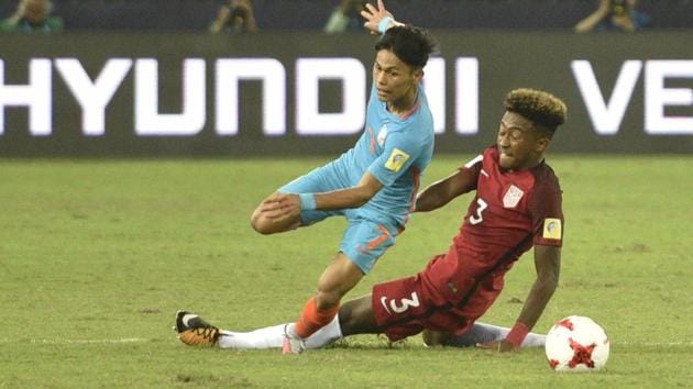 Nithoinganba Meetei of Indian U-17 football team (left) fights for the ball with Cris Gloster of USA U-17 team during their FIFA U- 17 World Cup match at Jawaharlal Nehru Stadium in New Delhi on Friday. India, despite losing 3-0, showed no signs that they were overawed by the occasion or by their much more seasoned opponents. (Mohd Zakir/HT PHOTO) Nithoinganba Meetei of Indian U-17 football team (left) fights for the ball with Cris Gloster of USA U-17 team during their FIFA U- 17 World Cup match at Jawaharlal Nehru Stadium in New Delhi on Friday. India, despite losing 3-0, showed no signs that they were overawed by the occasion or by their much more seasoned opponents. (Mohd Zakir/HT PHOTO)