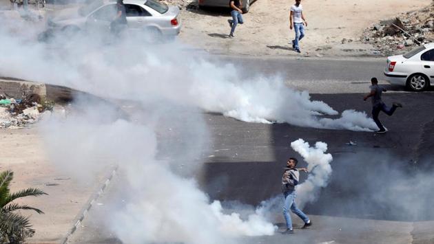A Palestinian protester hurls back a tear gas canister fired by Israeli troops during clashes in the West Bank city of Ramallah. (Mohamad Torokman / REUTERS) A Palestinian protester hurls back a tear gas canister fired by Israeli troops during clashes in the West Bank city of Ramallah. (Mohamad Torokman / REUTERS)