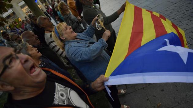Pro-independence supporters shout slogans in front of the Popular Party headquarters as a woman holds up ‘esteleda’ or pro-independence flag, in support of the Catalonia’s secession, in Pamplona, northern Spain, on October 6.(AP Photo)
